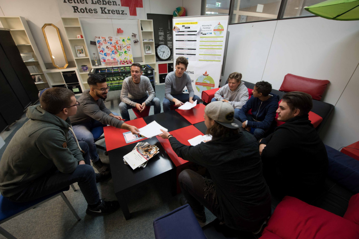 Schülersprecher und Verbindungslehrer sitzen im SMV-Raum um einen Tisch